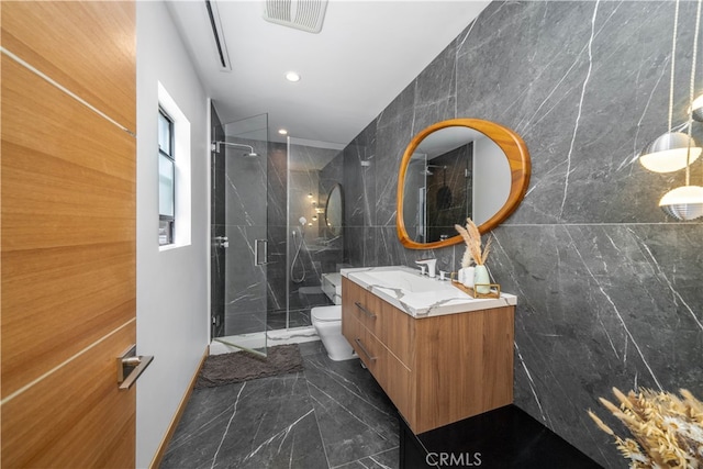 bathroom with vanity, tile walls, a shower with shower door, and toilet