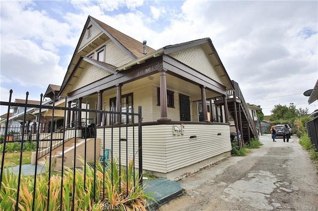 view of side of property featuring covered porch