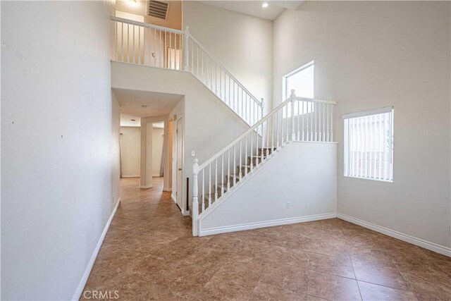 staircase with a high ceiling and tile patterned flooring