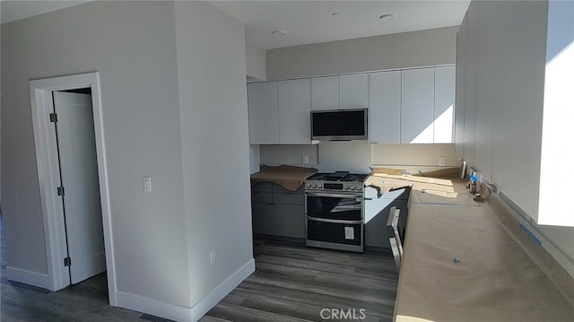 kitchen with gas stove, white cabinetry, and dark hardwood / wood-style floors