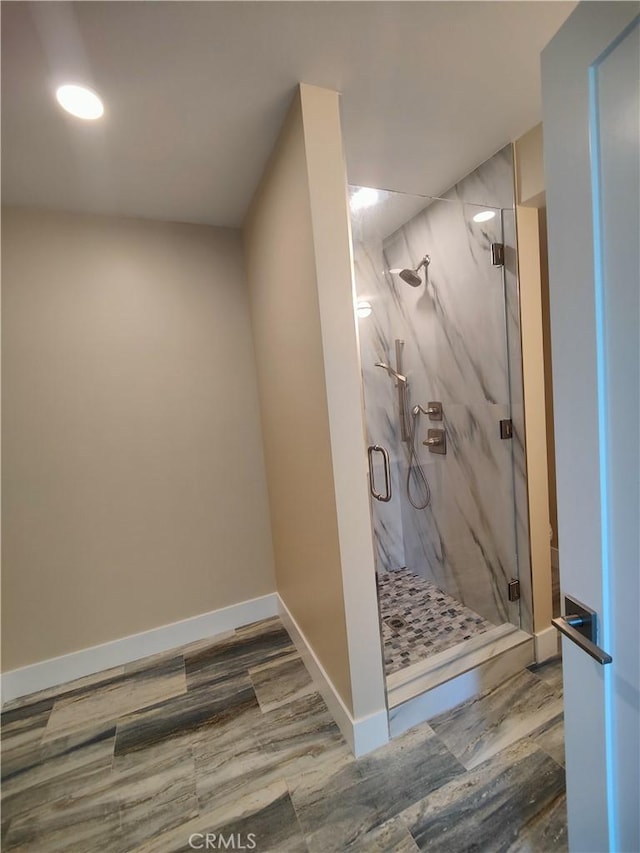 bathroom with hardwood / wood-style floors and a shower with shower door