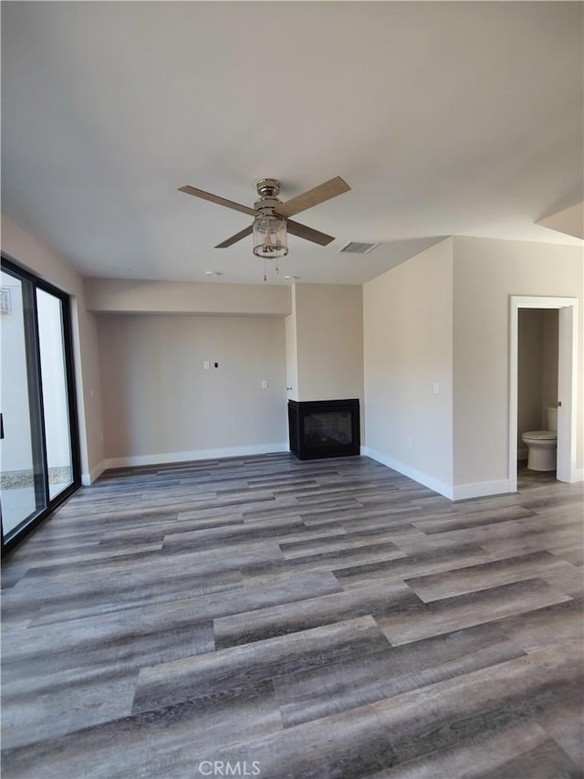 unfurnished living room featuring ceiling fan and hardwood / wood-style floors