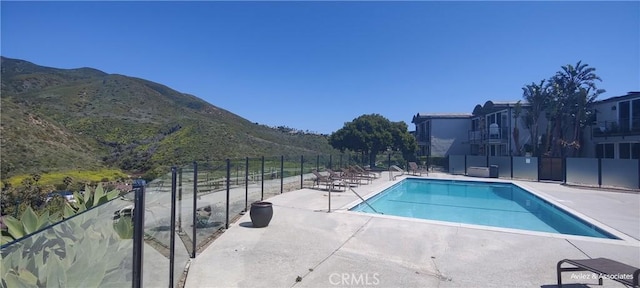 view of swimming pool with a mountain view and a patio