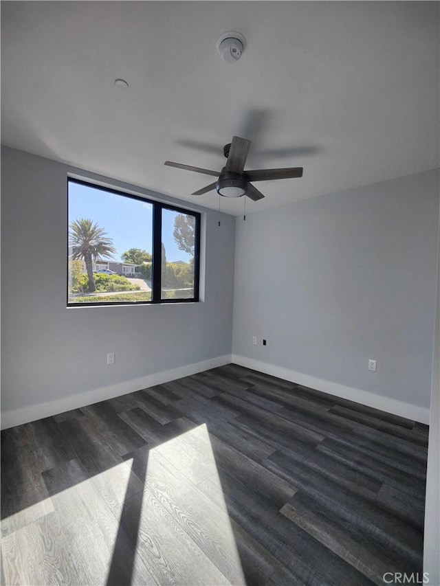 empty room featuring ceiling fan and dark wood-type flooring