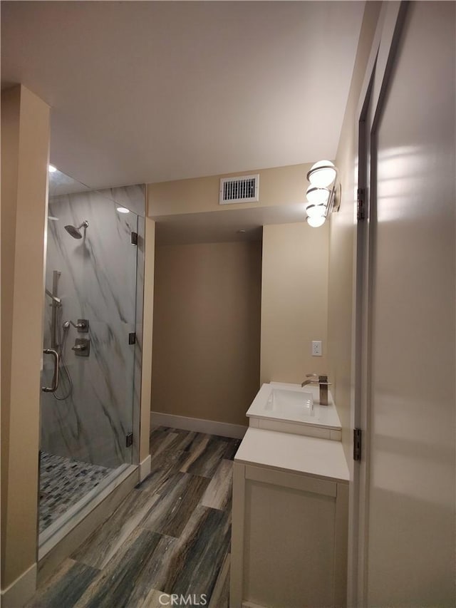 bathroom featuring vanity, hardwood / wood-style flooring, and a shower with door