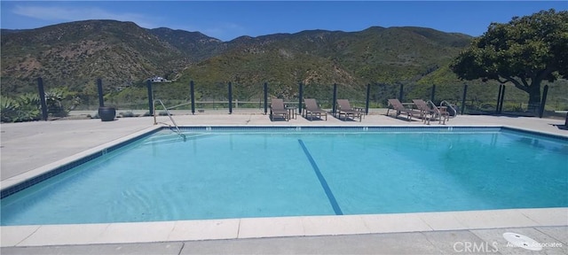 view of pool with a mountain view and a patio