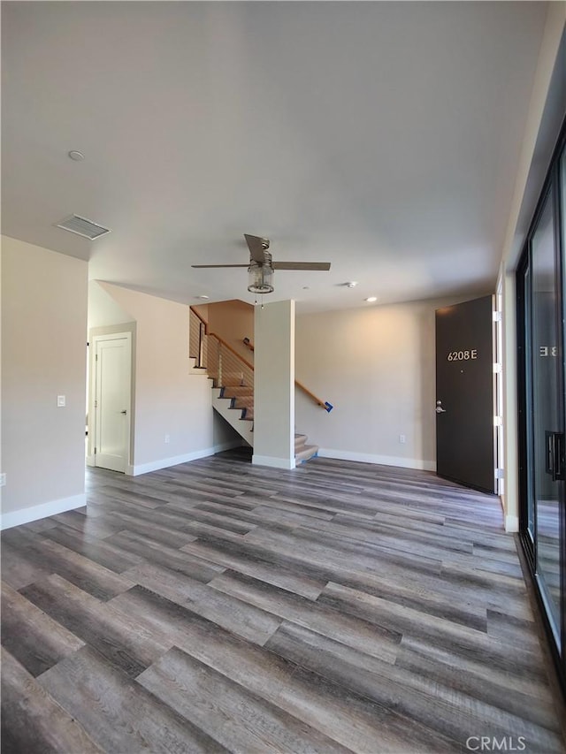 unfurnished living room with ceiling fan and dark wood-type flooring