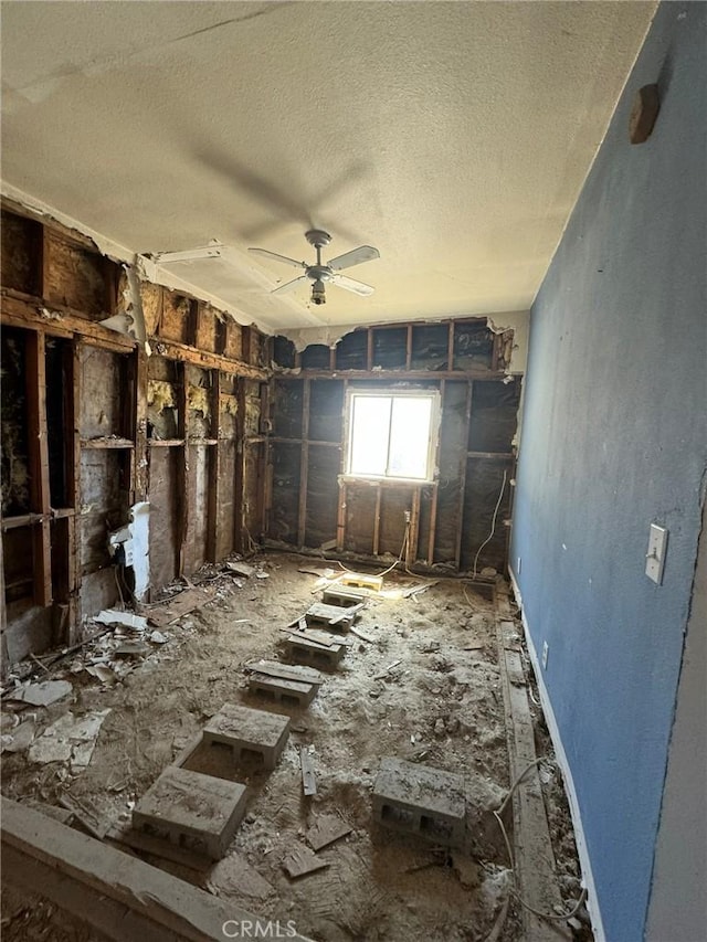 misc room with ceiling fan and a textured ceiling