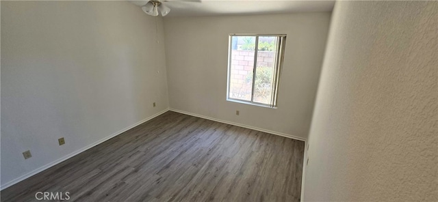 unfurnished room with ceiling fan and dark hardwood / wood-style flooring