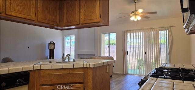 kitchen featuring ceiling fan, tile countertops, dark hardwood / wood-style floors, and sink