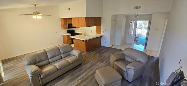 living room with sink, ceiling fan, dark wood-type flooring, and high vaulted ceiling