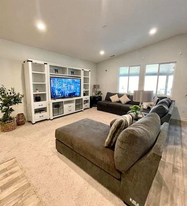 carpeted living room with lofted ceiling