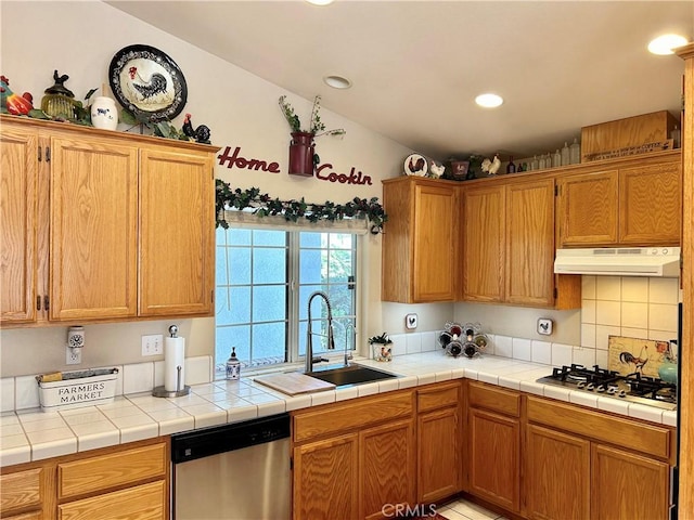 kitchen featuring tile countertops, decorative backsplash, sink, and stainless steel appliances