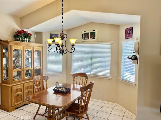 tiled dining space featuring a notable chandelier and lofted ceiling