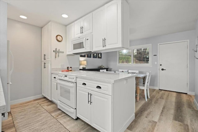 kitchen with white cabinets, light wood-type flooring, white appliances, and light stone counters