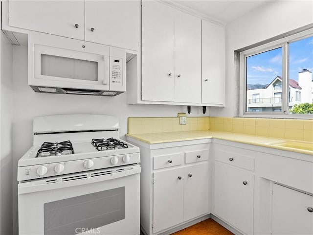 kitchen with white cabinetry and white appliances