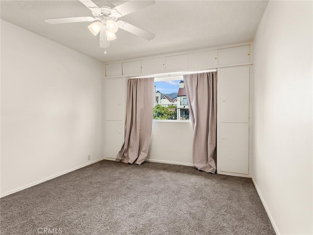 carpeted spare room with ceiling fan and a textured ceiling