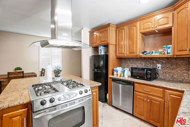 kitchen featuring island exhaust hood, light stone countertops, backsplash, black appliances, and light tile patterned floors