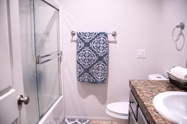 full bathroom featuring vanity, toilet, and shower / bath combination with glass door