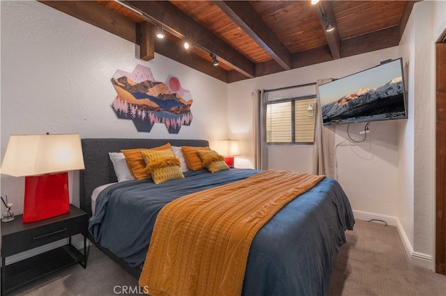 carpeted bedroom featuring rail lighting, wooden ceiling, and beam ceiling