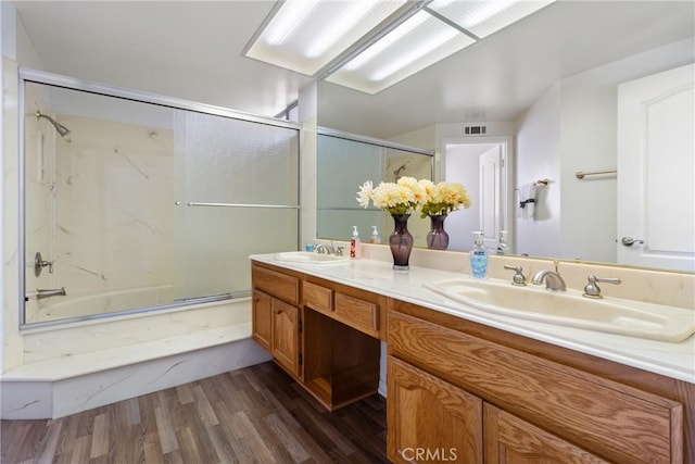 bathroom with wood-type flooring, vanity, and  shower combination