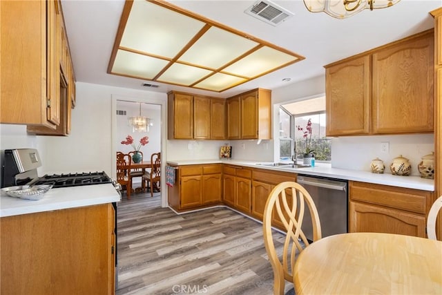 kitchen with gas range, sink, stainless steel dishwasher, a notable chandelier, and light hardwood / wood-style floors