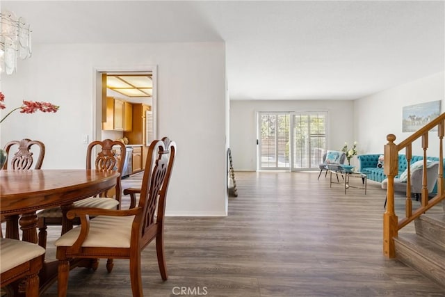 dining room with dark wood-type flooring and a chandelier