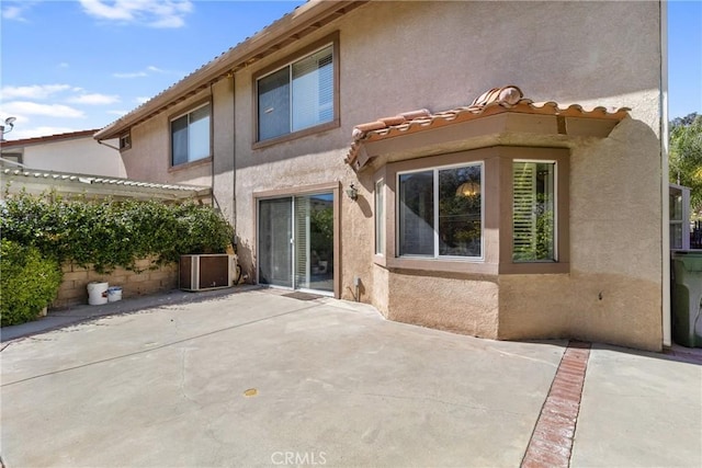 rear view of property with a patio and cooling unit