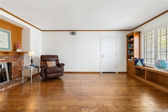 living area featuring crown molding, a fireplace, and wood-type flooring