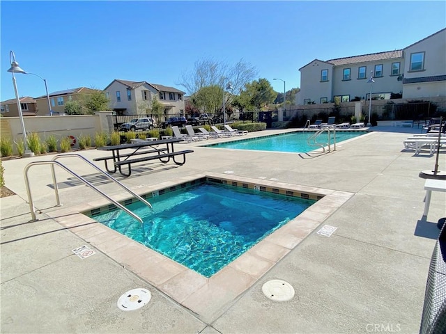 view of swimming pool featuring a patio area and a community hot tub