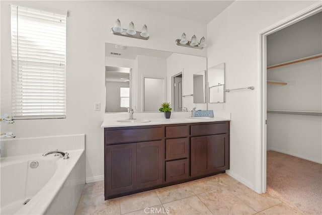 bathroom featuring a tub, tile patterned floors, and vanity