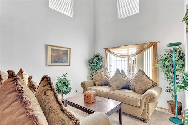 living room featuring a high ceiling and carpet flooring