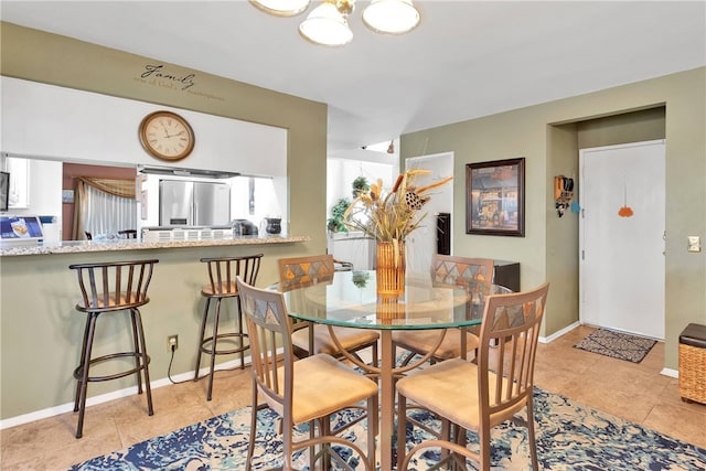 dining room featuring light tile patterned flooring and an inviting chandelier