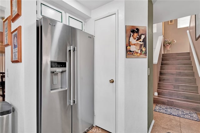 kitchen featuring a wealth of natural light, light tile patterned flooring, and stainless steel fridge