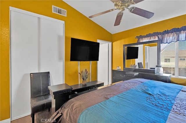 bedroom with a closet, vaulted ceiling, and ceiling fan