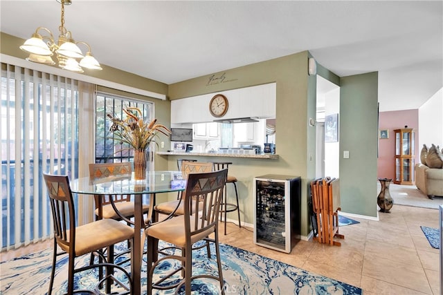 dining space with an inviting chandelier, beverage cooler, and light tile patterned floors