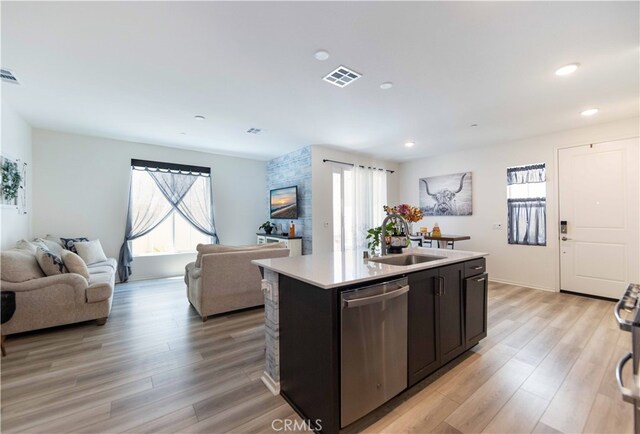 kitchen featuring light hardwood / wood-style floors, dishwasher, a kitchen island with sink, and sink