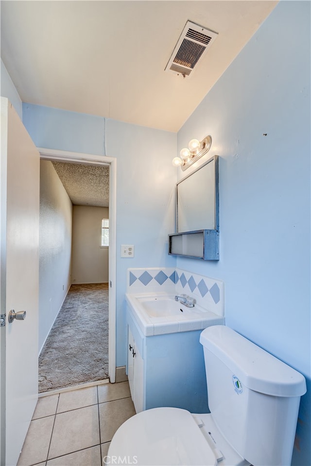 bathroom with vanity, toilet, and tile patterned flooring