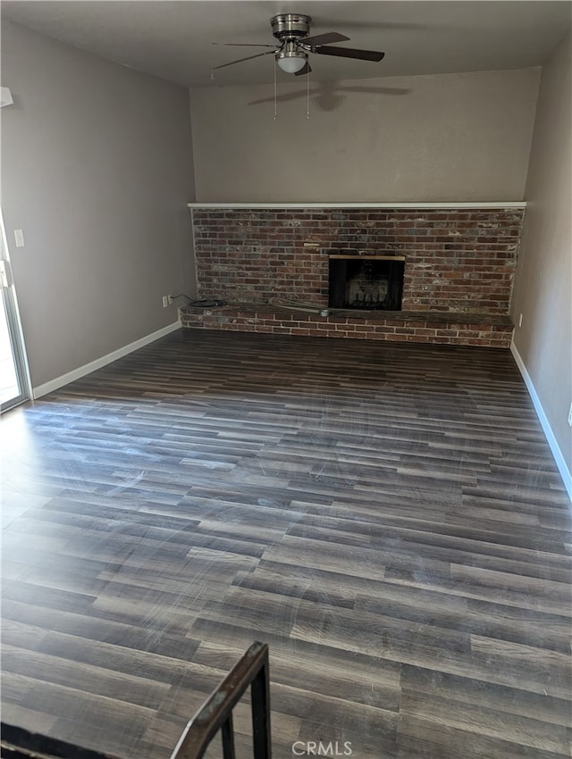 unfurnished living room featuring ceiling fan, a fireplace, and dark hardwood / wood-style flooring