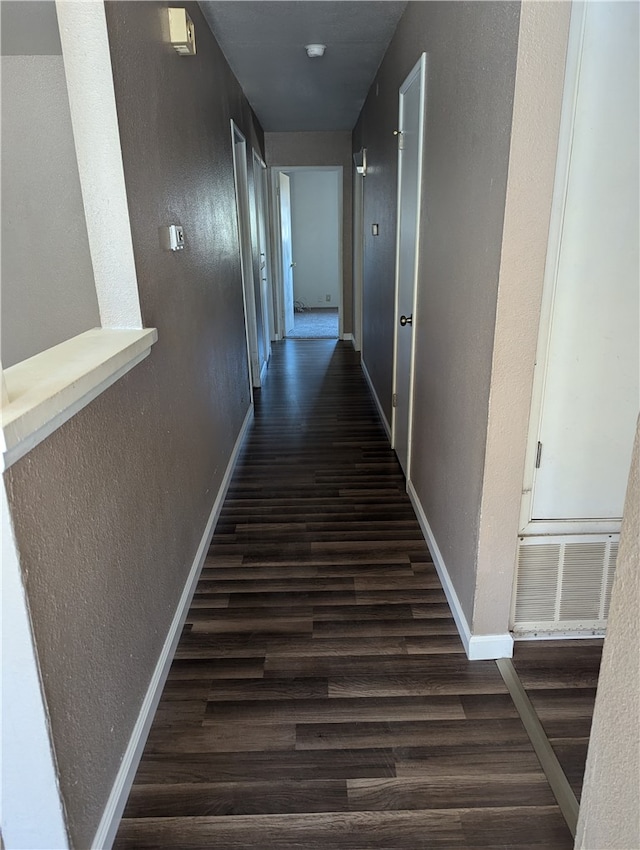 corridor with dark hardwood / wood-style flooring