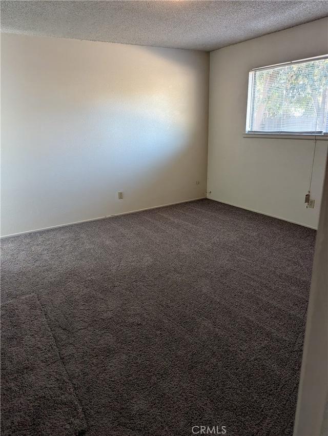 carpeted empty room featuring a textured ceiling