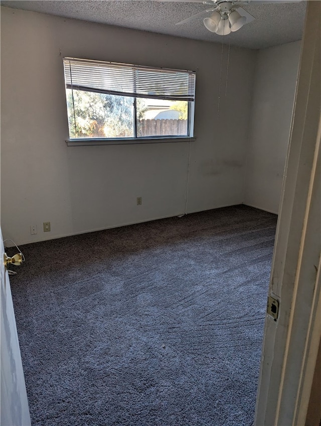 carpeted empty room featuring ceiling fan and a textured ceiling