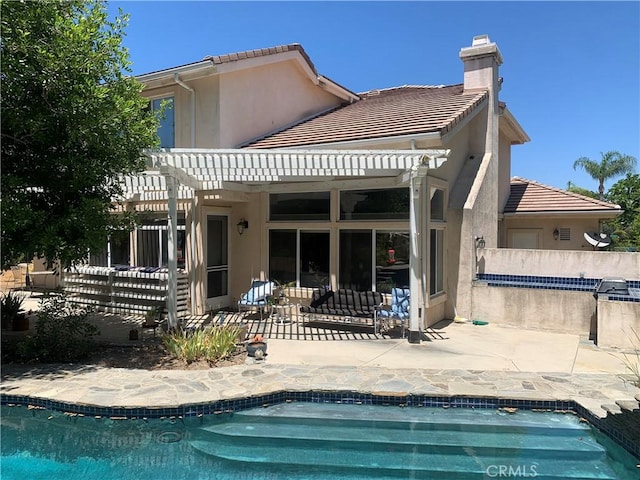 back of property with a pergola and a patio area