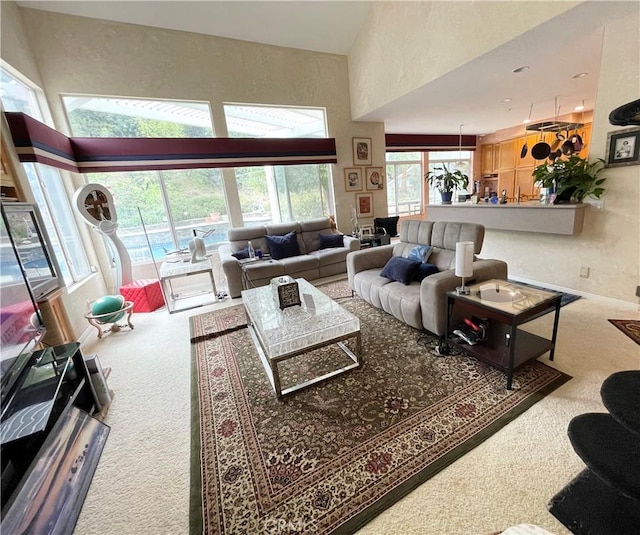 carpeted living room featuring a high ceiling