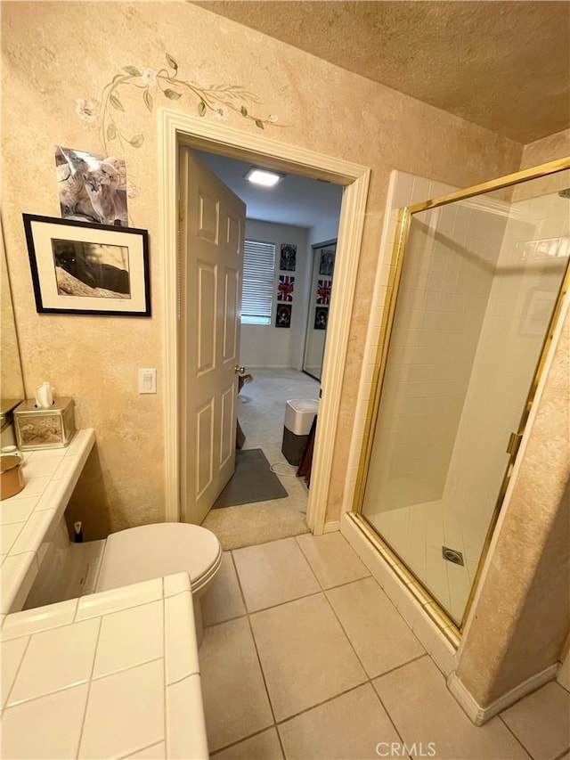 bathroom featuring toilet, tile patterned flooring, and walk in shower