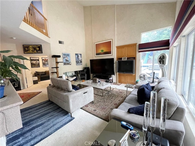 living room with carpet flooring and a towering ceiling