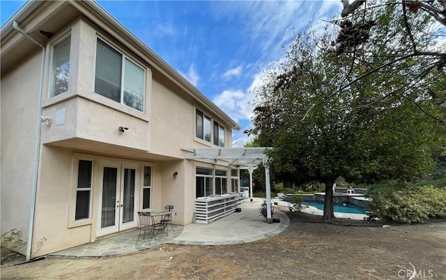 rear view of house with a pergola, french doors, and a patio