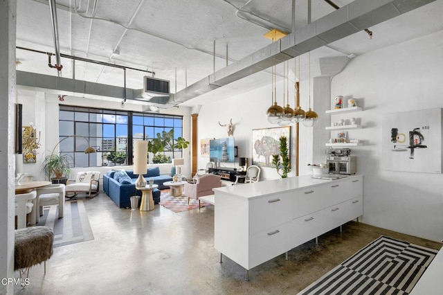 interior space with white cabinetry, a high ceiling, and pendant lighting