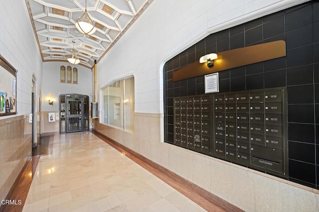 hall with lofted ceiling and mail boxes