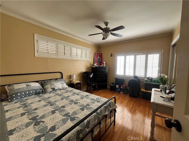 bedroom featuring ceiling fan, hardwood / wood-style floors, and crown molding